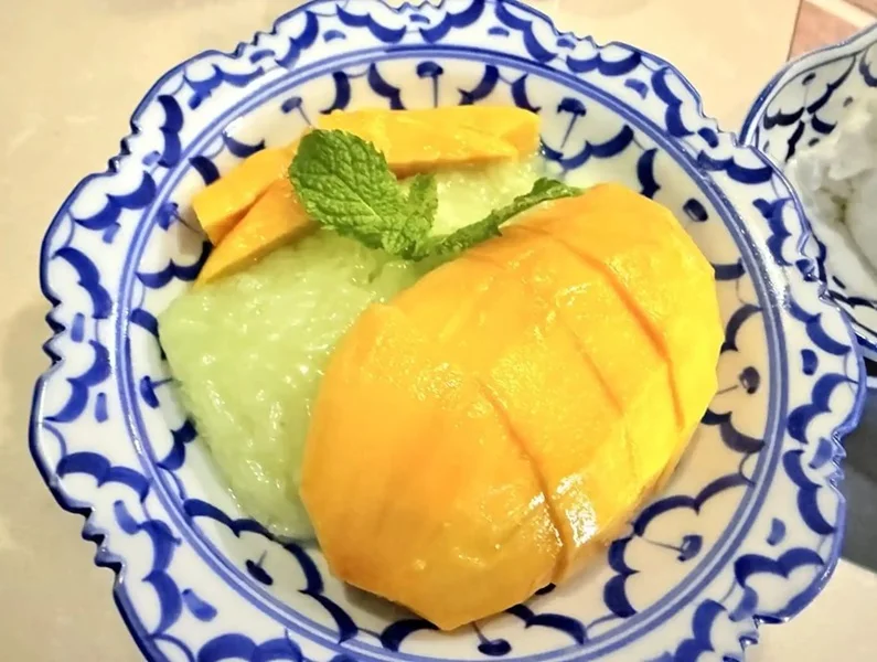 Mango Sticky Rice - Sweet glutinous rice drizzled with rich coconut cream and served alongside fresh ripe mango slices — the perfect Thai dessert experience.