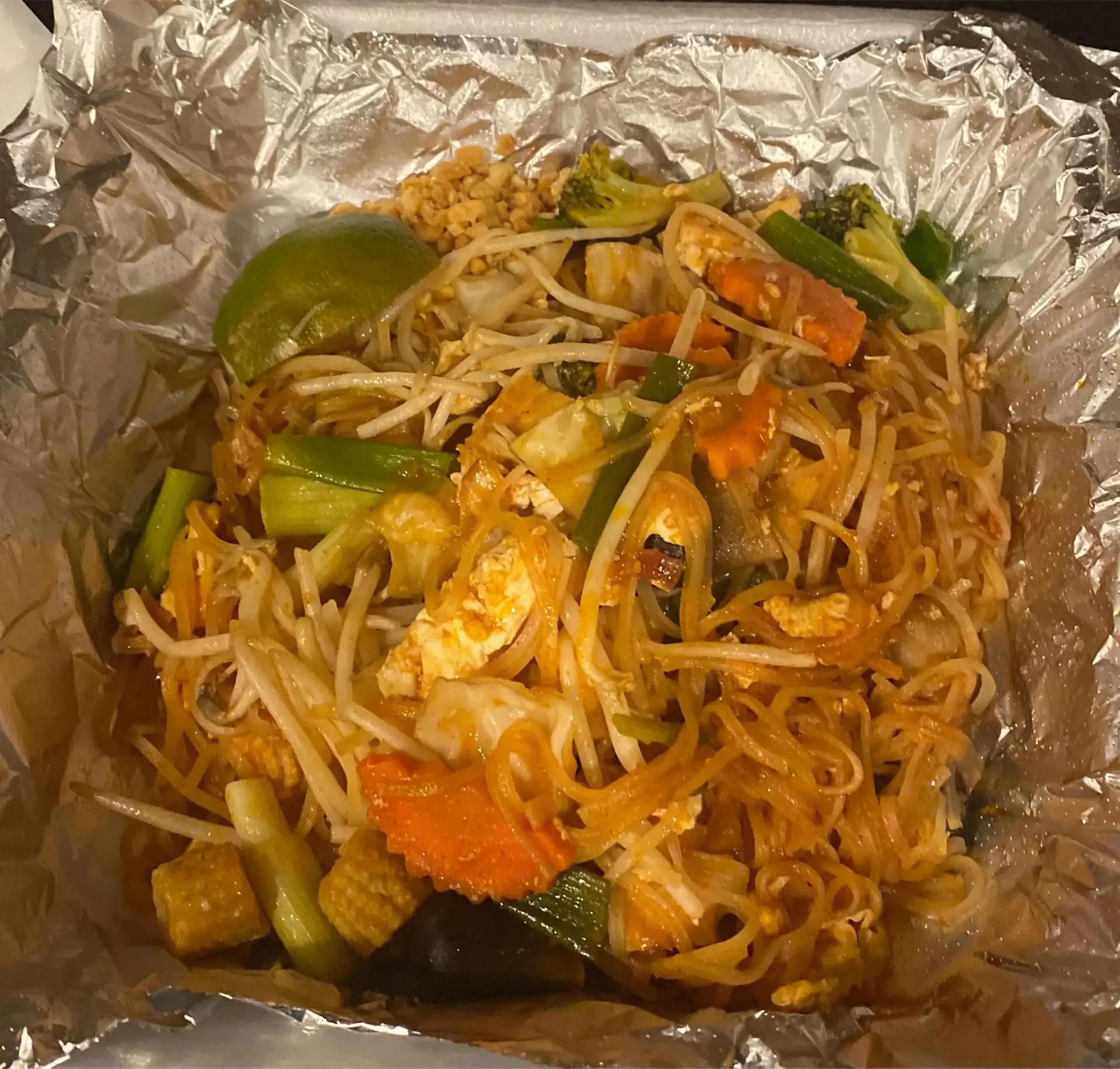 Pad Thai - Our most beloved dish — rice noodles stir-fried with egg, bean sprouts, and your choice of protein, finished with crushed peanuts and a squeeze of lime.